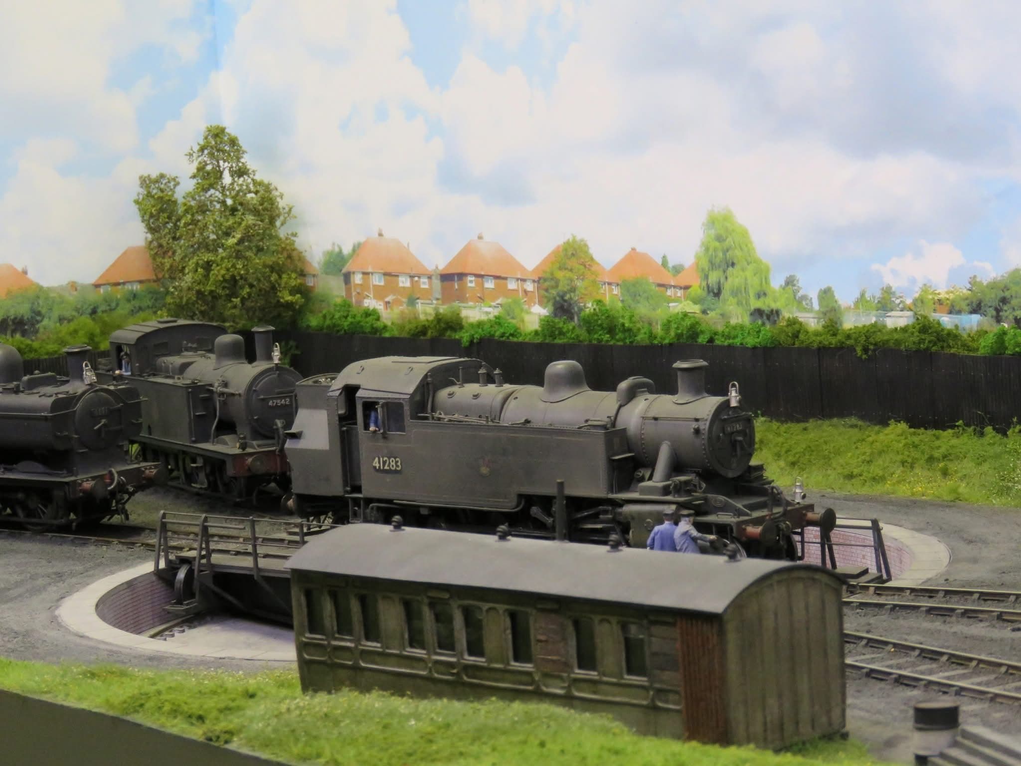 Tank engines 41283 and 47542 and a pannier tank on the shed roads beside the turntable, with an old coach body used as a hut in front