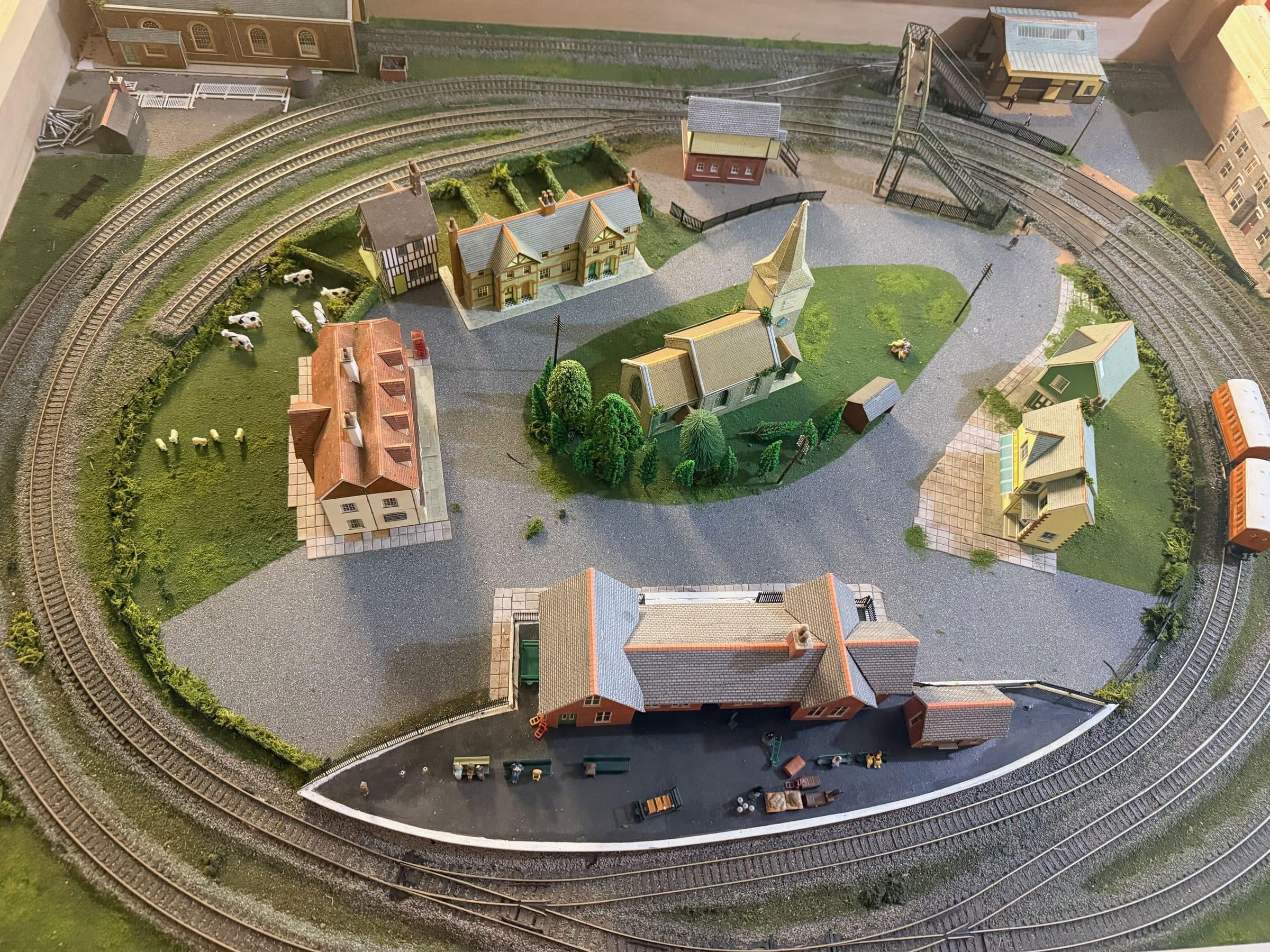 Looking down on the children's layout: a loop of track around a village with a church, houses and a station