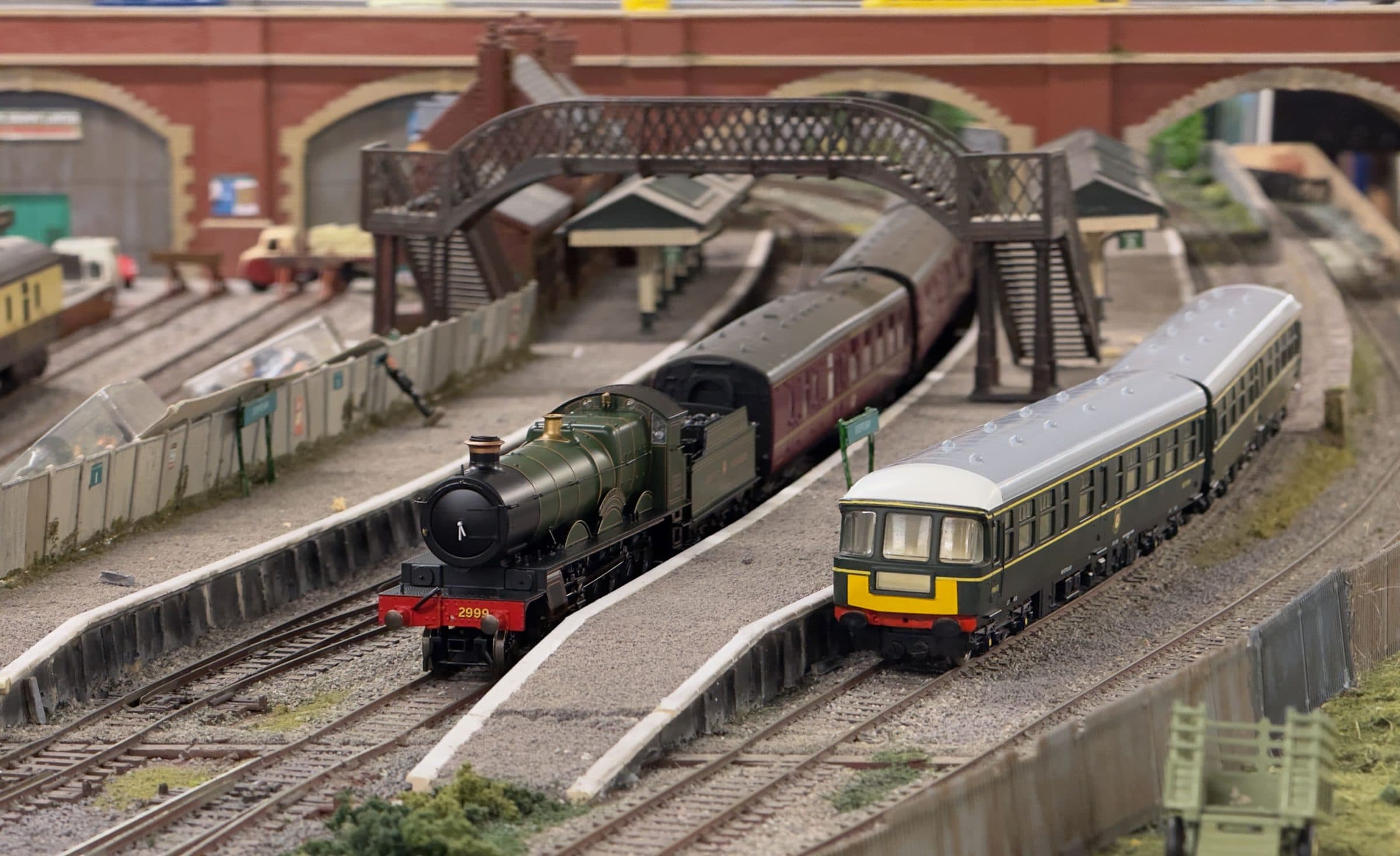 GWR 2999 Lady of Legend and a green diesel multiple unit side by side under the footbridge at Sterte Bay